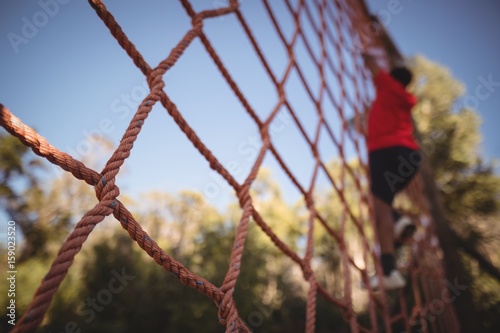 Boy climbing a net during obstacle course