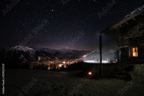 friends in jacuzzi in snowcovered mountain landscape under dark starry nightsky