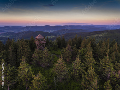 Sunset. Aerial view of the summer time in mountains near Czarna Gora mountain in Poland. Pine tree forest and clouds over blue sky. View from above. photo