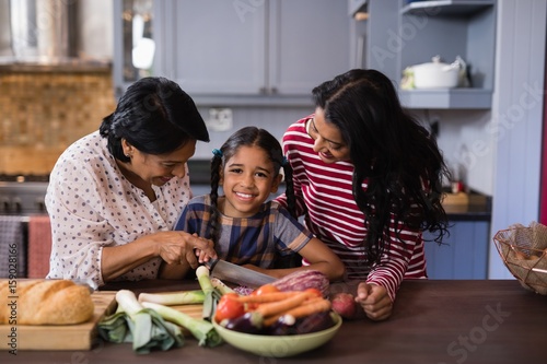 Girl preparing food with mother and grandmother