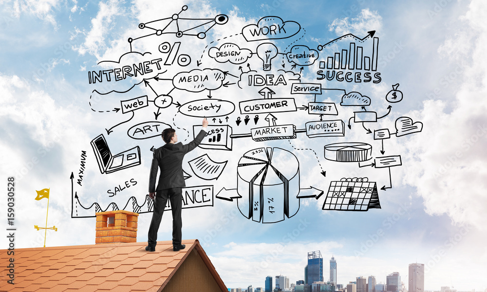 Rear view of businessman on house roof drawing his new business strategy. Mixed media Rear view of businessman on house roof drawing his new business strategy. Mixed media