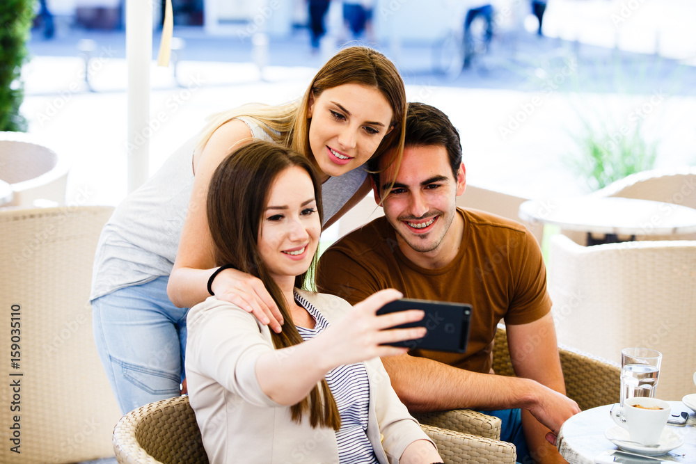 Three amazing friends taking selfie in caffe Three amazing friends taking selfie in caffe