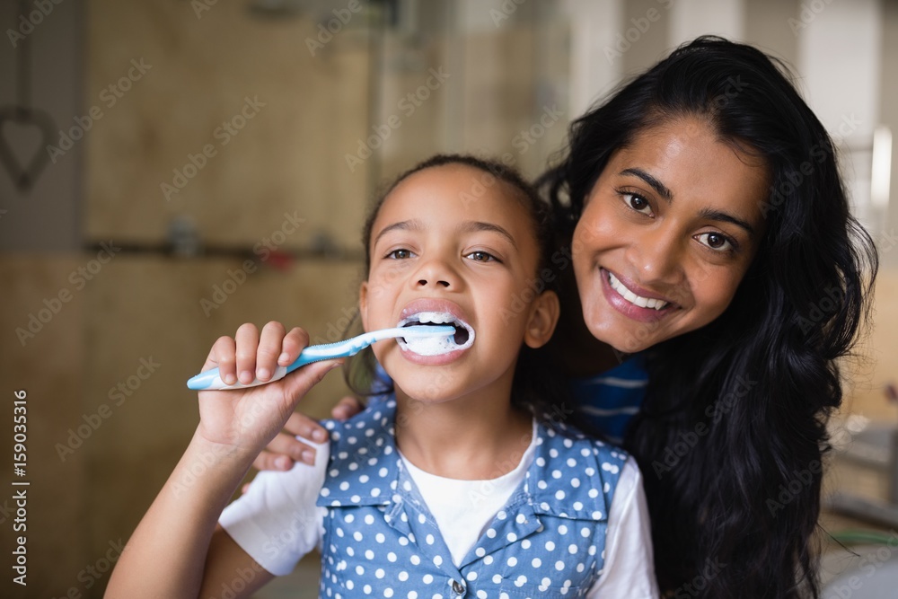 Girl brushing teeth with mother in bathroom Girl brushing teeth with mother in bathroom