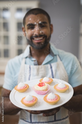 Portrait of happy man with desserts on plate photo