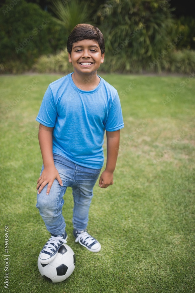 Portrait of smiling boy standing with soccer ball at park Portrait of smiling boy standing with soccer ball at park