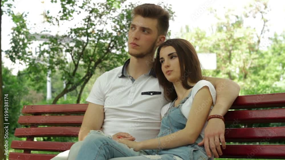 a guy with a girl hugging and talking on a bench in the Park a guy with a girl hugging and talking on a bench in the Park