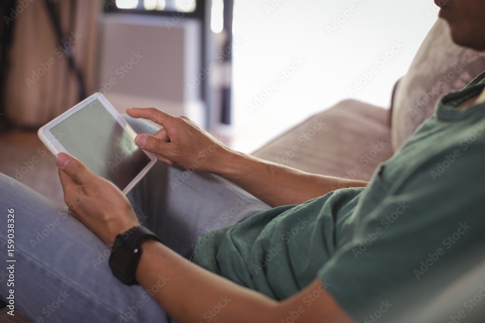 Man using digital tablet in living room Man using digital tablet in living room