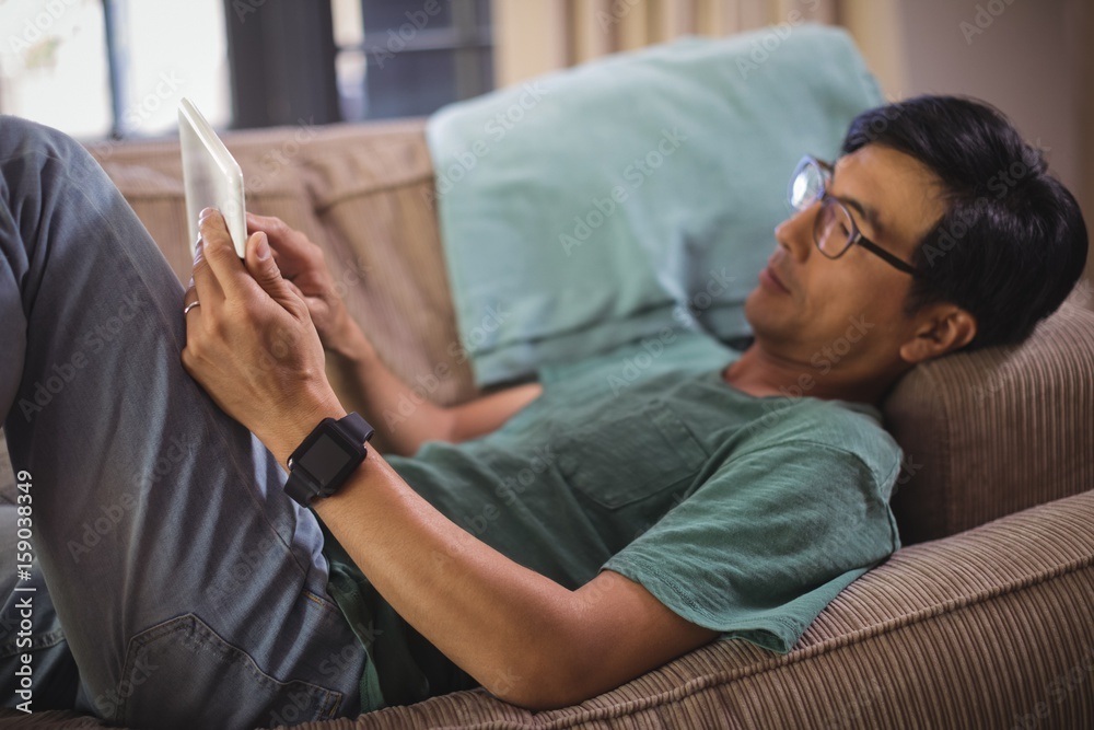 Fototapeta premium Man using digital tablet in living room