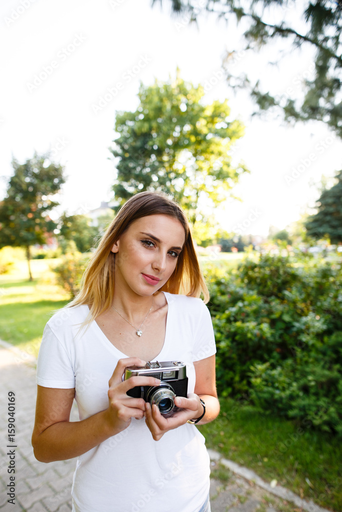 Attractive woman in park walking with her camera