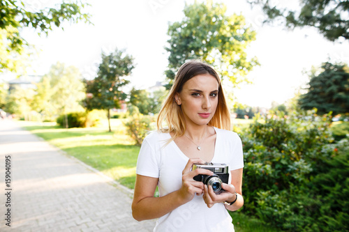 Attractive woman in park walking with her camera