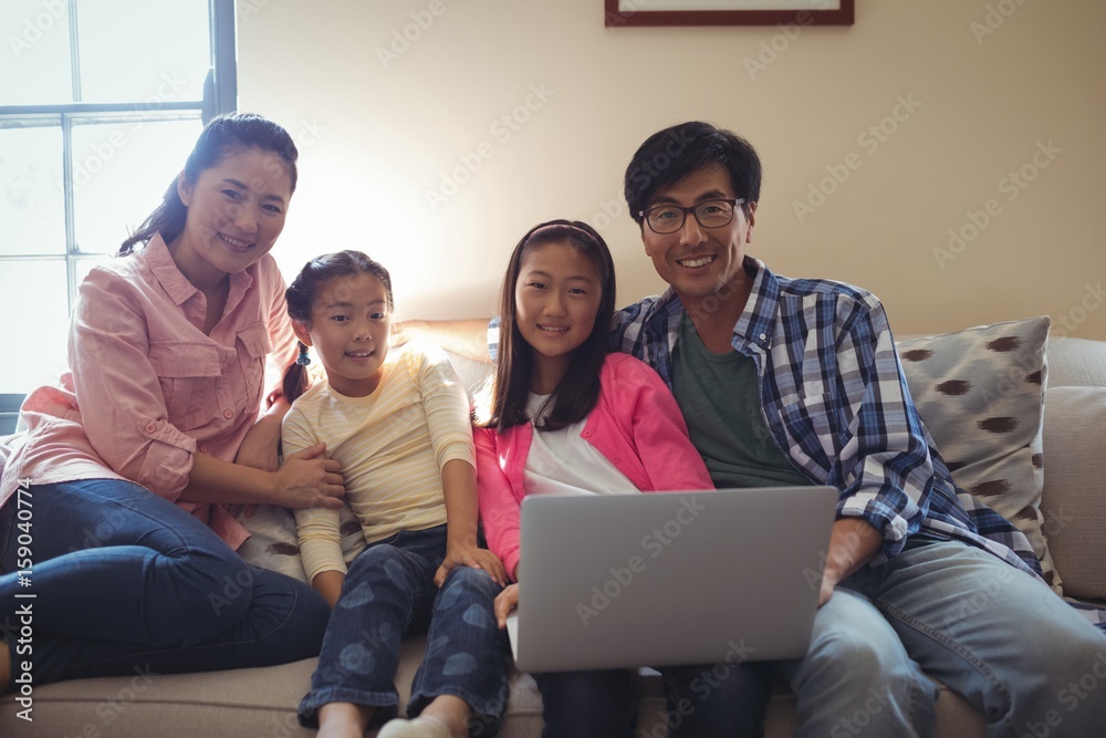Family using laptop together in living room Family using laptop together in living room