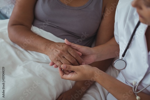 Female doctor examining hand of a senior woman
