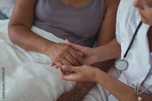 Фотография Female doctor examining hand of a senior woman