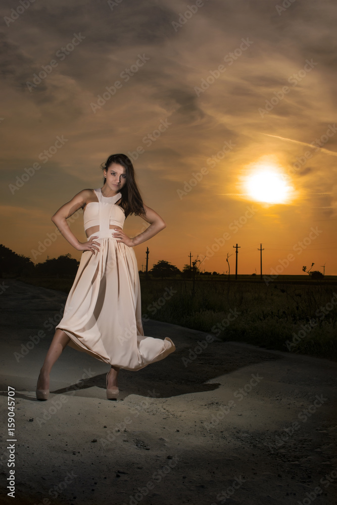Young girl at sunset wearing a long white dress Young girl at sunset wearing a long white dress
