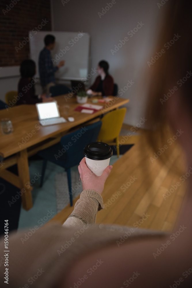 Female executive holding coffee cup