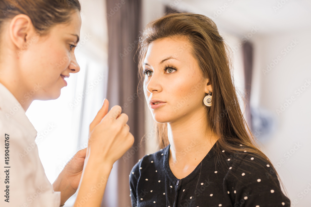 beauty and makeup concept - closeup portrait of beautiful woman getting professional make-up with brush beauty and makeup concept - closeup portrait of beautiful woman getting professional make-up with brush
