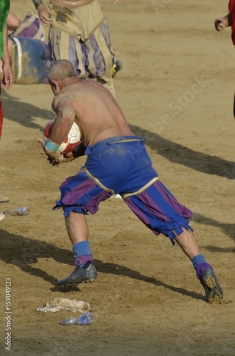 Calciante in azione che corre con la palla durante la partita di calcio storico fiorentino