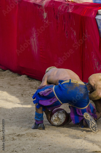 Calciante del calcio storico che sta raccogliendo la palla a terra photo