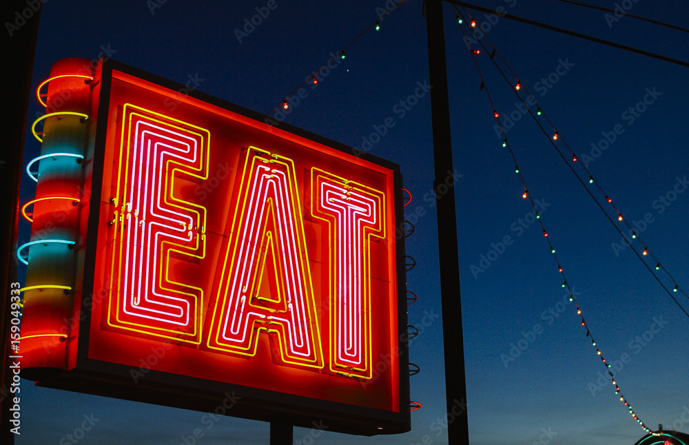 © Raymond Forbes LLC/Stocksy - Eat neon sign at night