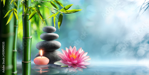 Fototapeta Spa - Natural Alternative Therapy With Massage Stones and Waterlily In Water