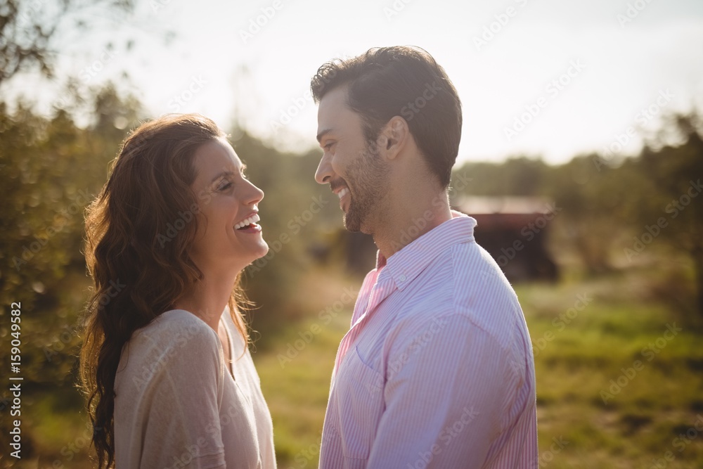 Happy young couple looking at each other at farm Happy young couple looking at each other at farm