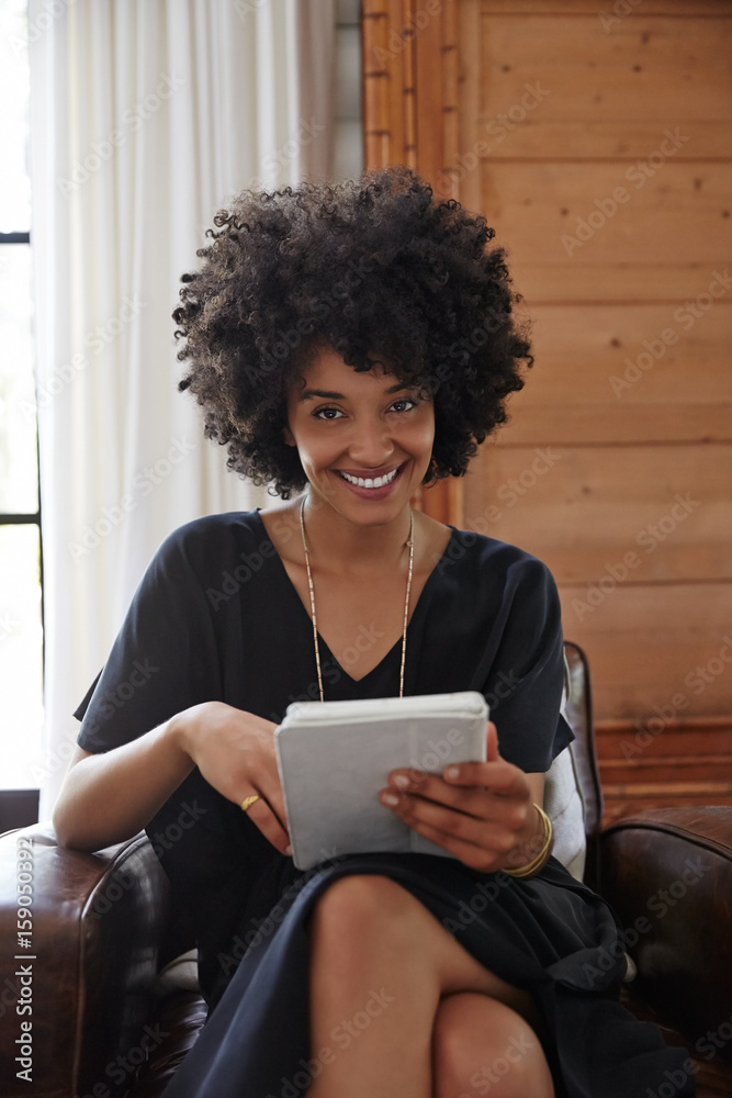 African American woman working on tablet in bedroom African American woman working on tablet in bedroom