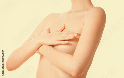 Woman covering her breast with hands photo