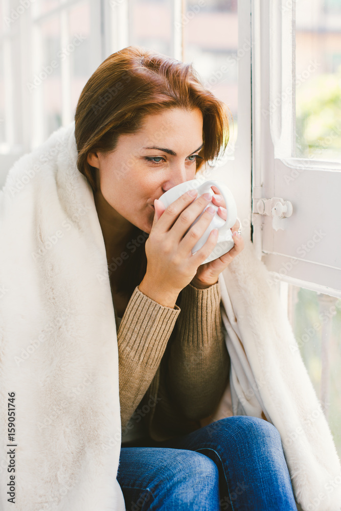 Mature woman drinking a coffee covering with blanket at home Mature woman drinking a coffee covering with blanket at home