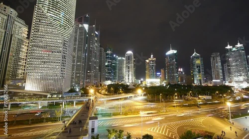 time lapse,busy city traffic & walking people silhouette on flyover,brightly lit urban finance skyscraper at night,shanghai landmark building,huanqiu-building,shimao.use Ultra-wide-angle lens shoot.	 photo