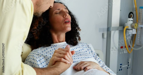 Man comforting pregnant woman during labor in ward photo