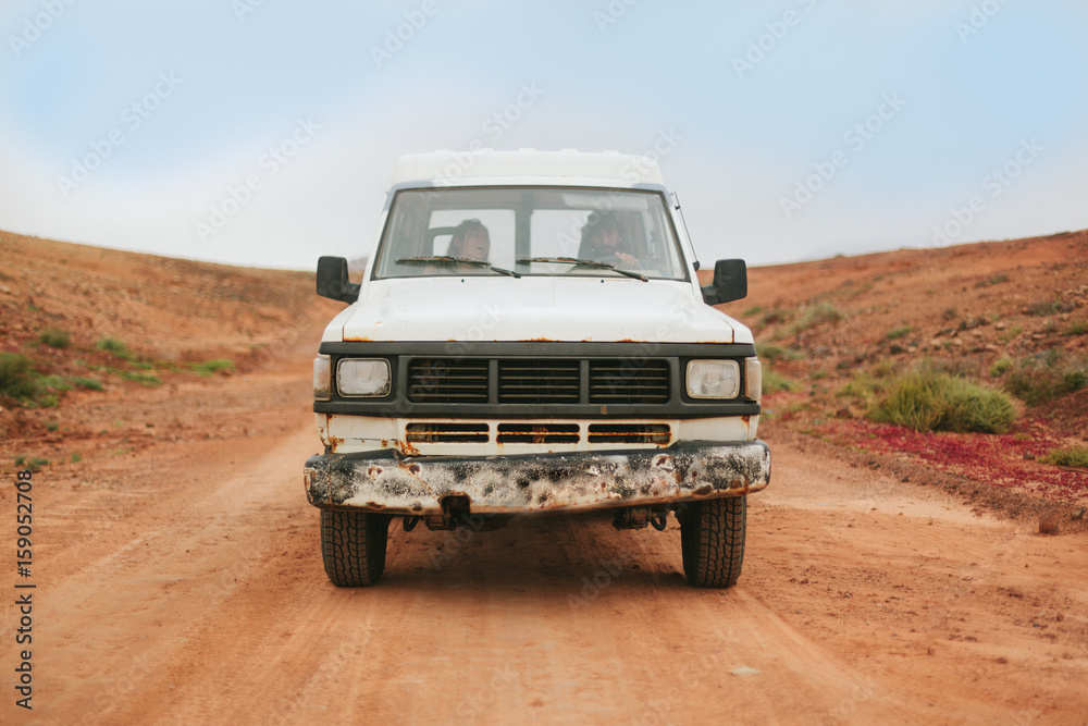 Couple in Adventure with Car in the Middle of the Desert Area Couple in Adventure with Car in the Middle of the Desert Area