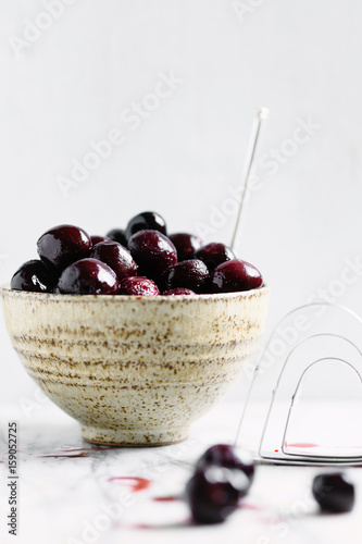 Frozen cherries in a bowl against a white background
