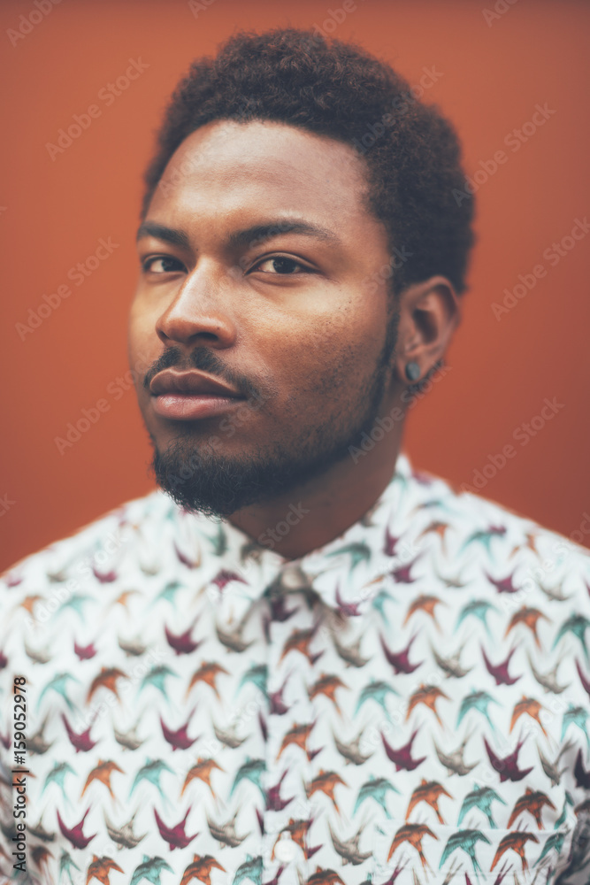 Portrait of modern young black man in front a orange wall Portrait of modern young black man in front a orange wall