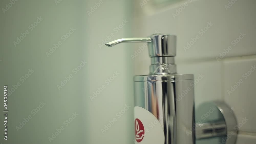 Man pushes a portion of liquid soap on the palm