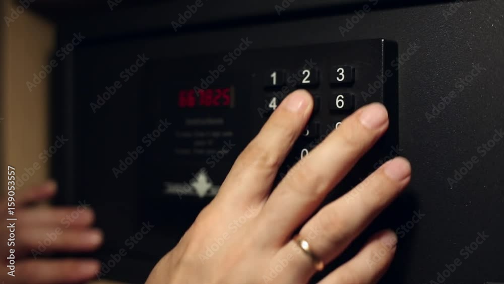 A man enters the secret code on a safe deposit box and opens the door