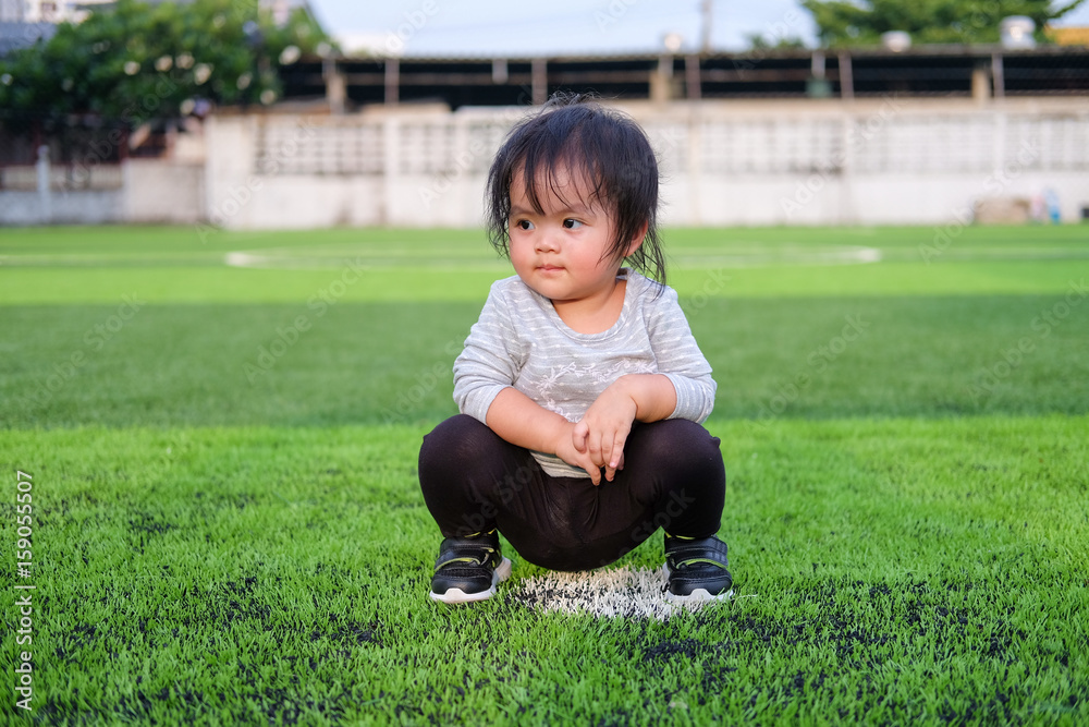 Cute asian baby girl playing on football field. Portrait of Asian beautiful baby girl of 1 year and 3 months old. Cute asian baby girl playing on football field. Portrait of Asian beautiful baby girl of 1 year and 3 months old.