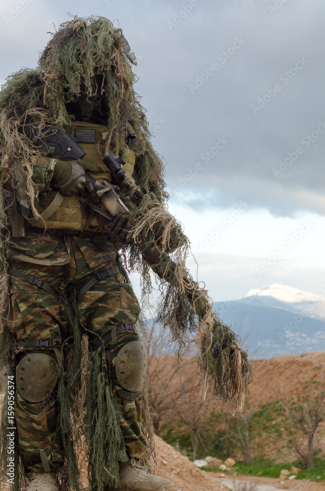 Foto de Kneeling sniper firing position ghillie uniform do Stock