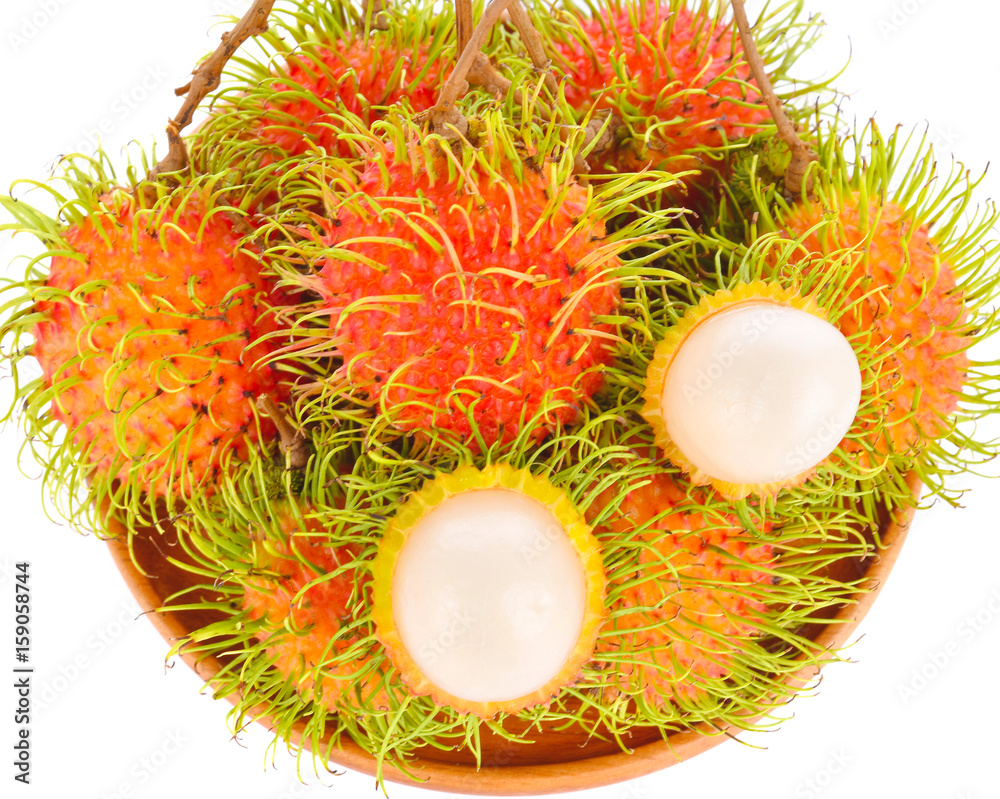 Rambutan in a wooden tray on a white background Rambutan in a wooden tray on a white background