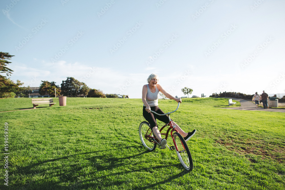 Vibrant mature woman enjoying herself on a bicycle Vibrant mature woman enjoying herself on a bicycle