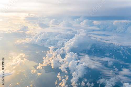 Fototapeta Naklejka Na Ścianę i Meble -  White clouds and blue sky at sunrise, view from above air plane window.