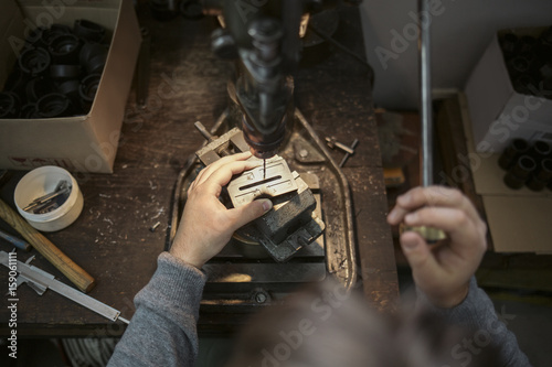 Man Drilling a Hole in a Metal Plate photo