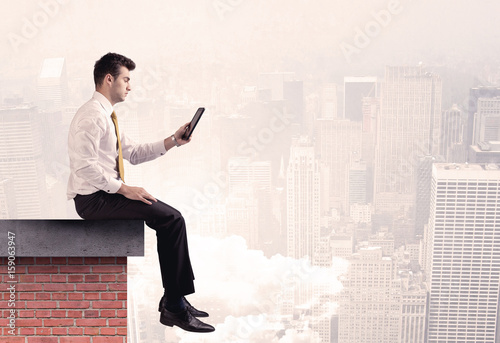 Office worker sitting on rooftop in city © ra2 studio