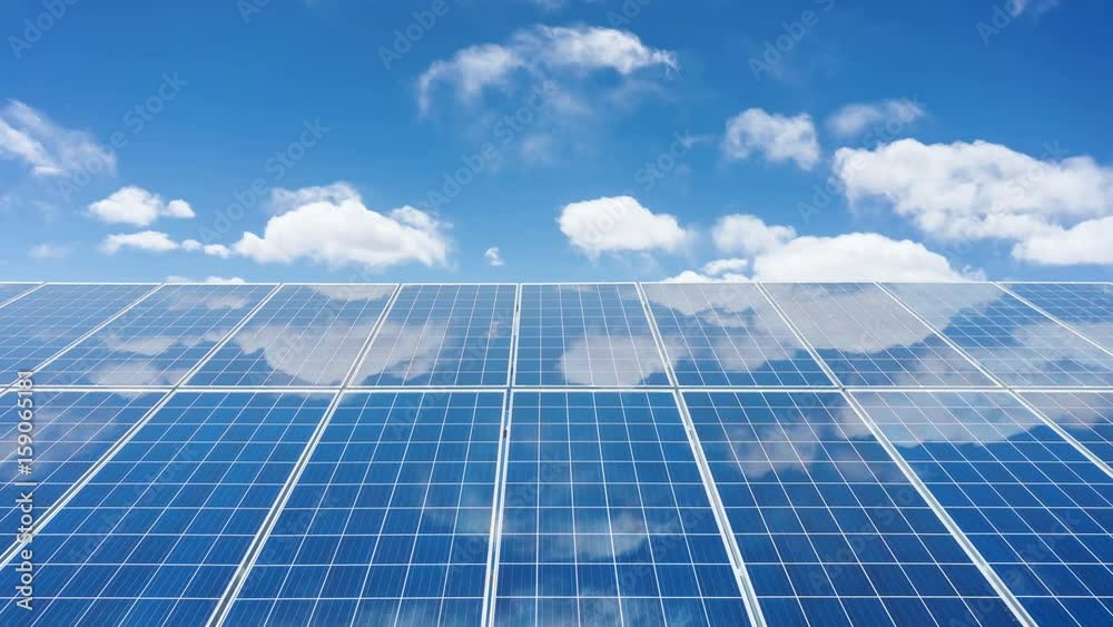 time lapse of solar panels with clouds in the back