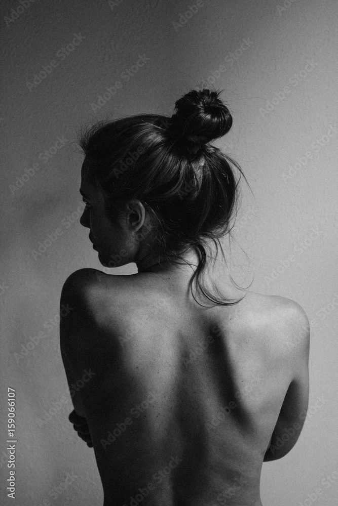 young woman with bare back towards camera intimate studio black and white  foto de Stock | Adobe Stock