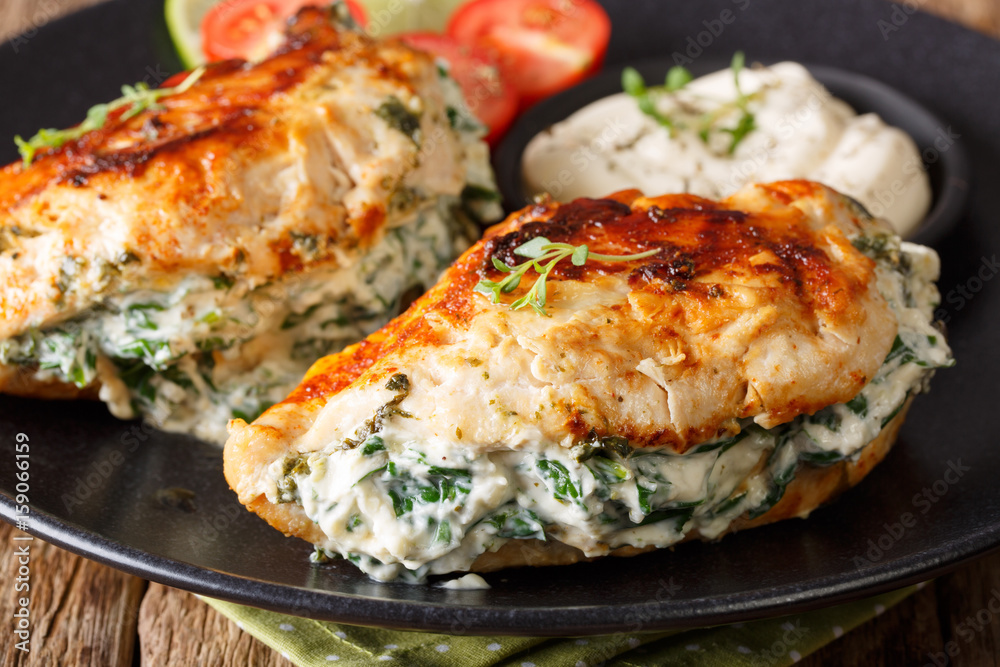 Fried chicken breasts filled with cheese and spinach, and with sauce close-up. horizontal Fried chicken breasts filled with cheese and spinach, and with sauce close-up. horizontal
