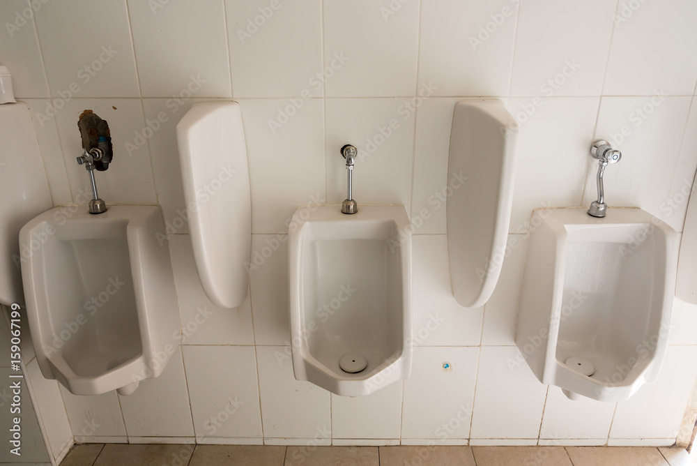 Fototapeta premium White porcelain urinals in public toilets.