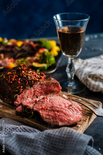 Sliced Grilled Beef rump steak on wooden board with vegetables