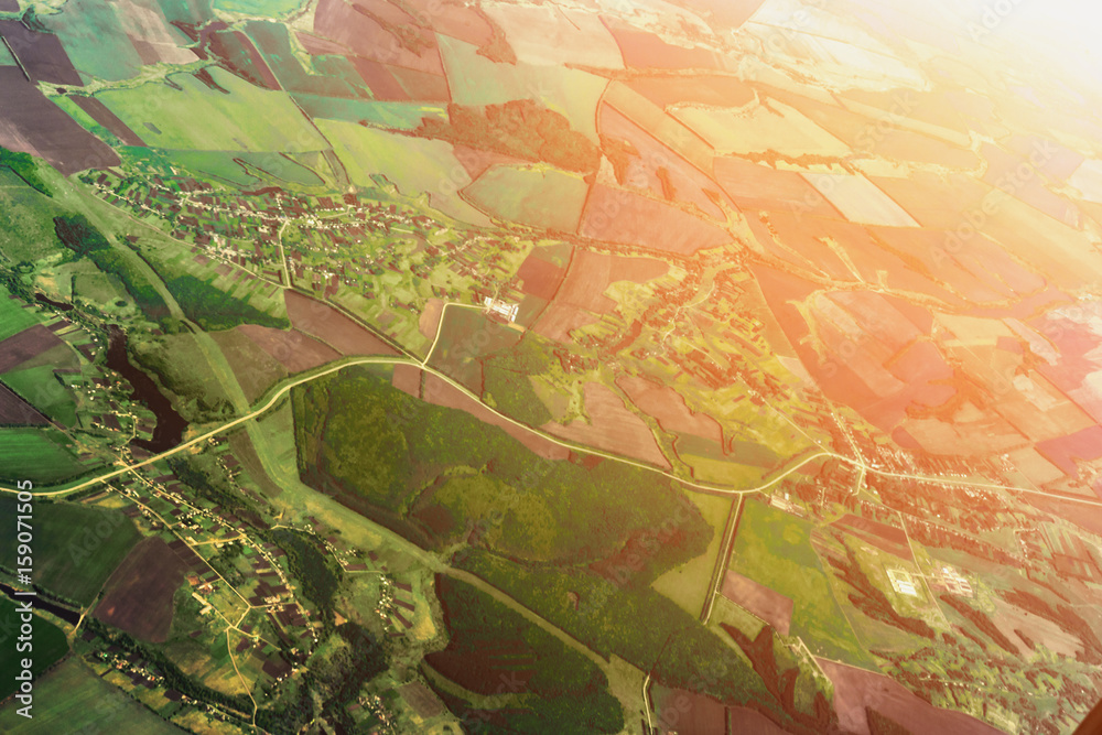 Fototapeta premium Aerial view from airplane, earth, green fields, roads, villages landscape