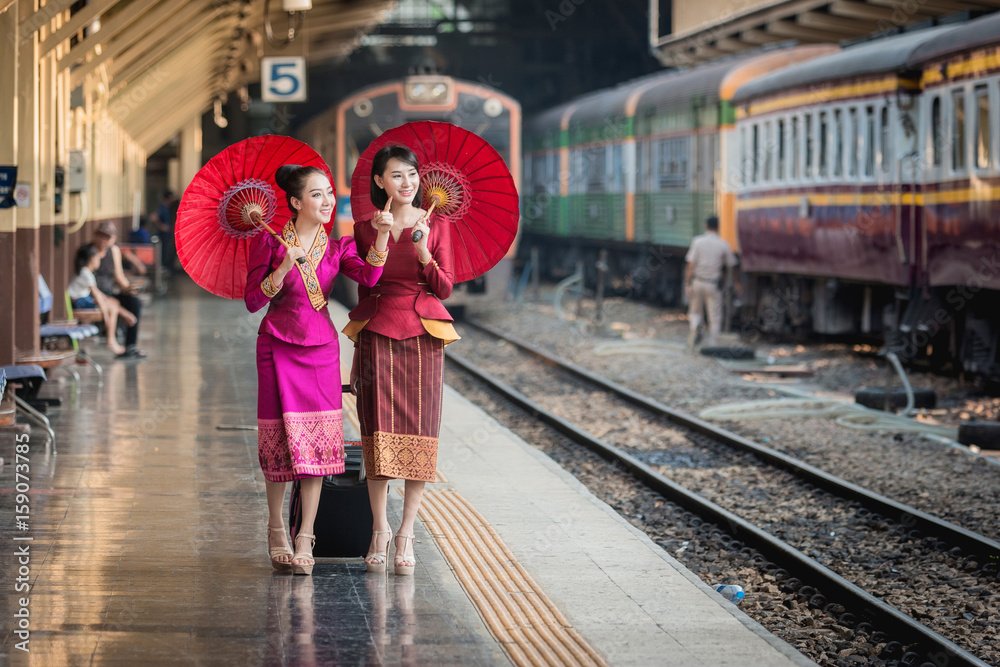 Fototapeta premium Piękna dziewczyna w tajskim stroju, azjatycka kobieta ubrana w tradycyjną tajską kulturę na stacji kolejowej w Bangkoku.