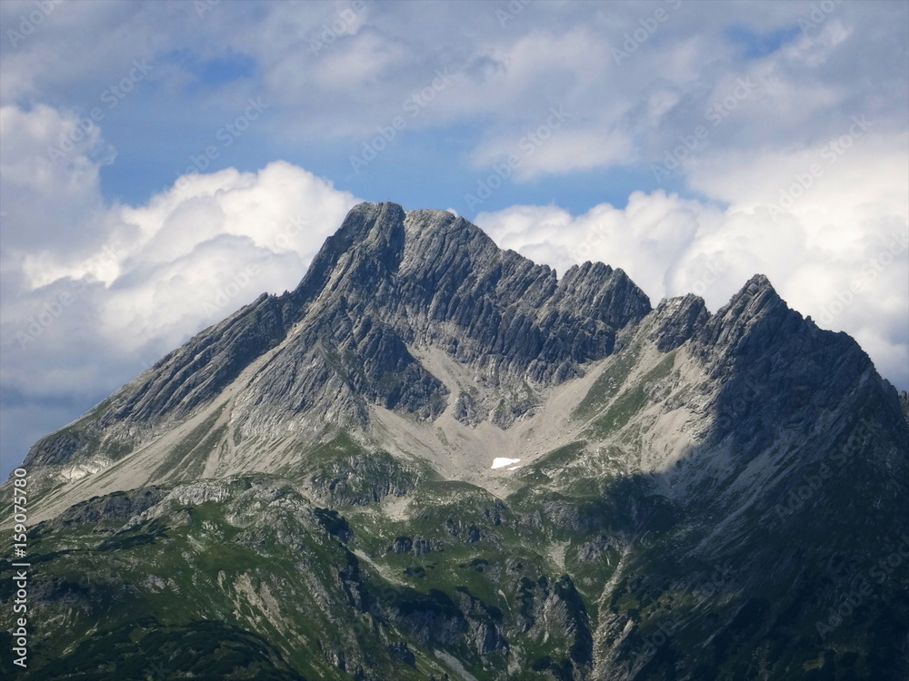 Climate change: last remainder of snow instead of an alpine glacier in the bowl shaped depression formed by the mountain glacier in the process of centuries. Lech Valley, Austria, August 2015.